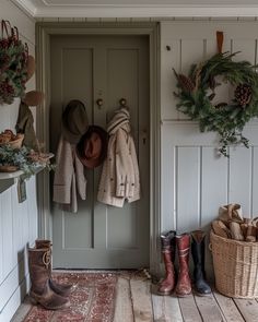 the entryway is decorated for christmas with wreaths and hats hanging on the door