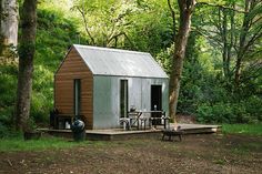 a small cabin in the woods with a picnic table