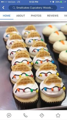 cupcakes with white frosting and colorful lights on them are lined up next to each other