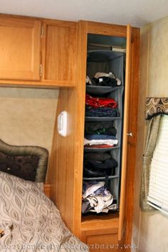 the closet is full of clothes and other things to put in it's storage compartment