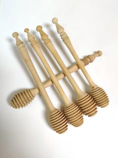 six wooden utensils lined up on a white surface