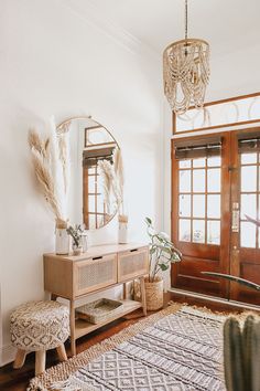 a living room with a rug, table and mirror