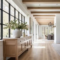 a large room with lots of windows and wood flooring on both sides of the room