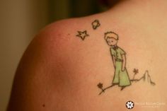 the back of a woman's shoulder with a drawing of a boy and stars on it