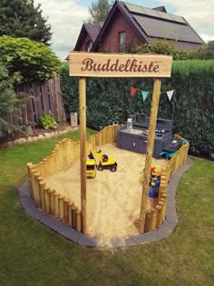 there is a sand pit in the yard with two children's toys on it