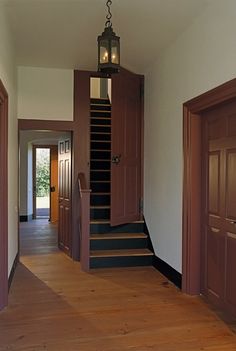 an empty hallway with stairs leading up to the second floor and another door on the other side