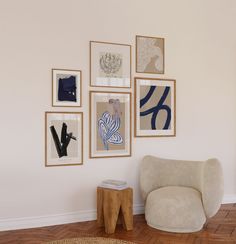 a white chair sitting next to a wall with pictures on it