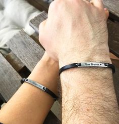 two people are sitting on a bench and one is wearing a black leather bracelet with the words hope forever engraved on it