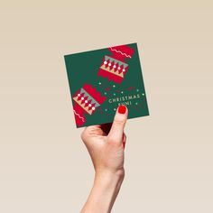 a person holding up a christmas card in their hand