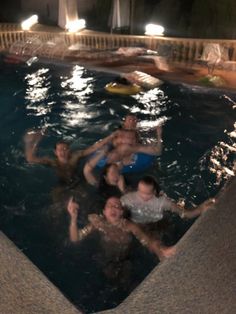 several people are in the pool at night