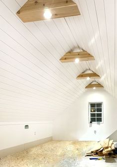 an unfinished room with white walls and wood beams