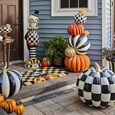 pumpkins and gourds are sitting on the front porch for halloween decorating