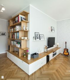 a living room filled with furniture and a flat screen tv on top of a wooden shelf