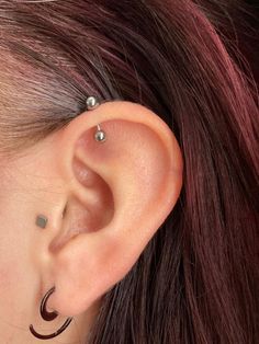 a close up of a person with ear piercings on their ears and behind the ear