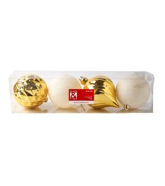 three gold and white ornaments in a package