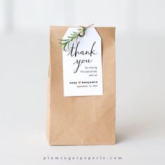 a brown paper bag with a thank you tag hanging from it's side on a white background