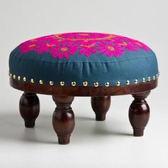 a foot stool made out of wood and fabric with pink flowers on the top, along with gold studding