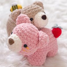 two small crocheted teddy bears sitting on top of each other in pink and white