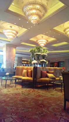 a fancy hotel lobby with couches and chandeliers