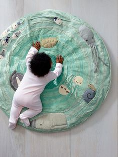 a baby is playing with an ocean themed play mat