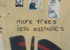 graffiti on the side of a building that says, more trees less ashbless