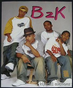 a group of young men sitting next to each other in front of a sign that says b - 2k