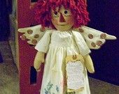 a doll with red hair is standing in front of a door and holding a piece of paper