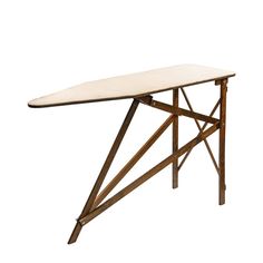 an ironing board sitting on top of a wooden table with white cloth under it