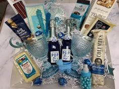 a gift basket filled with wine, snacks and other items sitting on a counter top