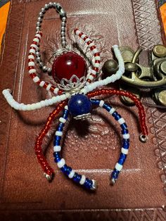 two bracelets are sitting on top of a leather book with metal clasps and beads