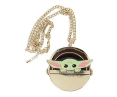 the child yoda necklace has a chain around it and is hanging on a white background