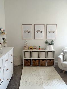 a living room with white furniture and pictures on the wall, including two chairs in front of a dresser