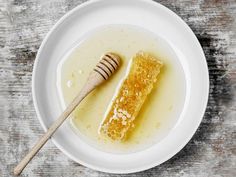 a white plate topped with honey and a wooden spoon