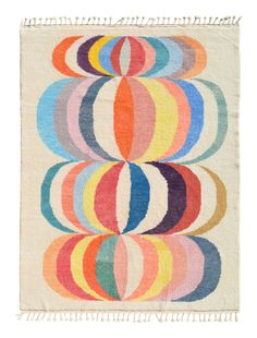 a multicolored rug with fringes on the bottom and an oval design in the middle