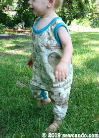 a toddler is standing in the grass