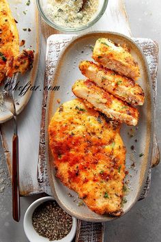 two plates with food on them, one has chicken and the other has bread in it