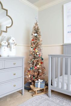 a baby's room with a christmas tree and crib in the corner next to it