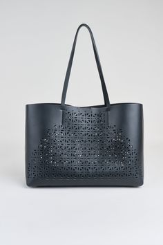 Prepare to be captivated by the chic, contemporary laser cut design of our exclusive Tote bag. Made in Italy in a luxe Napa Leather, it effortlessly blends style and function. The spacious interior ensures you can carry all your essentials with ease, while the interior removable pouch adds functionality - ideal for work, travel, or leisure. Elie Tahari Exclusive Napa Leather Lasercut Tote Handbag 100% Leather Made in Italy Approx. Measurements: Base 16" W x 4.5"D, 11.5 "H, Top Opening 18.5 " W, Luxury Bags With Perforations For Daily Use, Leather Bags With Perforations For Everyday Use, Leather Bag With Perforations For Daily Use, Chic Evening Bag With Interior Card Slots, Chic Evening Bags With Interior Card Slots, Luxury Perforated Shoulder Bag, Perforated Tote Shoulder Bag For Everyday Use, Chic Leather Shoulder Bag With Perforations, Everyday Perforated Tote Shoulder Bag