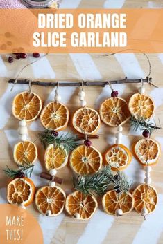 an orange slice garland is hanging on a wooden table with pine needles and dried orange slices