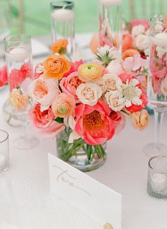 a vase filled with flowers on top of a table next to candles and napkins