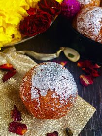 two round cakes sitting on top of a table covered in powdered sugar and rose petals