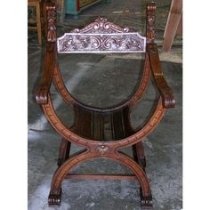 an ornate wooden chair sitting on top of a floor