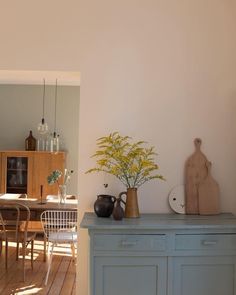 a dining room table and chairs with vases on it