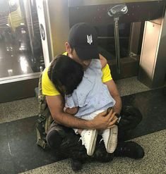 a man sitting on the ground holding a child