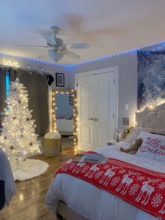 a bedroom decorated for christmas with lights on the ceiling and a tree in the corner