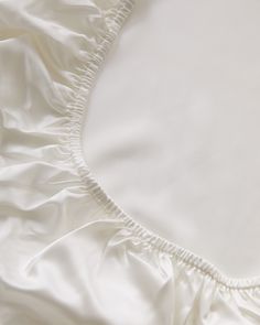 an unmade bed with white sheets and pillows