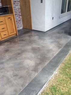 a concrete patio that has been cleaned and sealed off by the side of a house