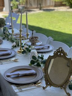 the table is set with plates and place settings