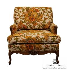 an old fashioned chair with floral fabric and wood trimming on the armrests