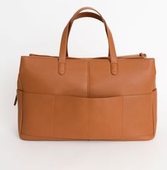 a tan leather handbag is shown against a white background with the handles folded down